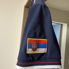 大阪・関西万博セルビア館のセルビア人スタッフ用ポロシャツ。ベオグラード万博2027ピンバッジ付きの画像