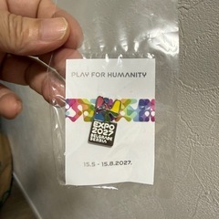 大阪・関西万博セルビア館のセルビア人スタッフ用ポロシャツ。ベオグラード万博2027ピンバッジ付きの画像