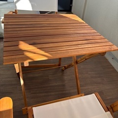 木製テーブルとホワイトチェアセット　アウトドアの画像