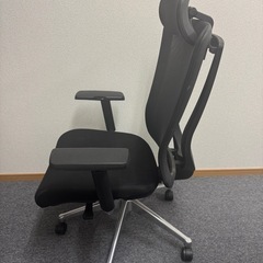 メッシュバックと可動式ヘッドレストを備えたオフィスチェア。の画像