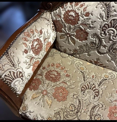 クラシックな花柄の刺繍が施された布製のソファ