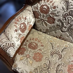 クラシックな花柄の刺繍が施された布製のソファの画像
