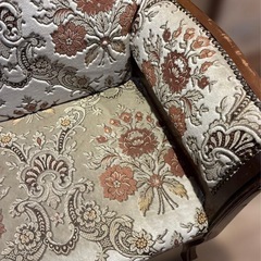 クラシックな花柄の刺繍が施された布製のソファの画像