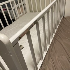 白いベビーベッドとベビー布団の画像