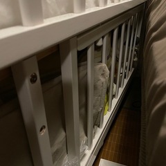 白いベビーベッドとベビー布団の画像