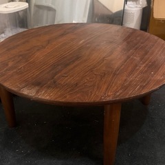 ブラウンの木製折りたたみ丸テーブルの画像