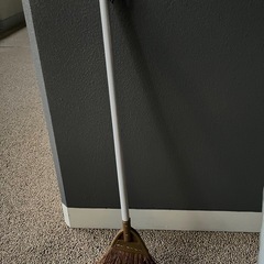 大きめのビニール傘とホウキの画像