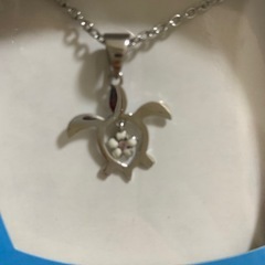 ウミガメのネックレスとハンカチの画像