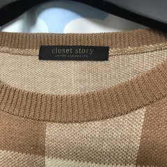 ブラウン系のチェック柄が特徴の長袖ニットセーター。
の画像