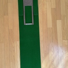 ゴルフバッグとパター練習用マットの画像