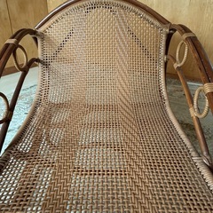 ラタン製のオープンデザインバウンサー、手編み仕上げでブラウンカラー。 の画像