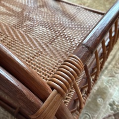 ラタン製のオープンデザインバウンサー、手編み仕上げでブラウンカラー。 の画像