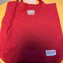 「Keep Calm and Carry On」の文字と王冠のロゴが入った赤いトートバッグの画像