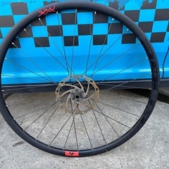 ALEXRIMS XC 30の黒いリアホイール、ディスクブレーキ対応、赤いロゴが特徴。の画像