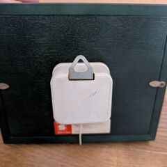 壁掛けタイプのオルゴールと木製の椅子（飾り）の画像