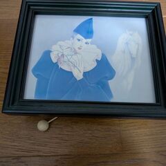 壁掛けタイプのオルゴールと木製の椅子（飾り）の画像