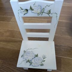 壁掛けタイプのオルゴールと木製の椅子（飾り）の画像