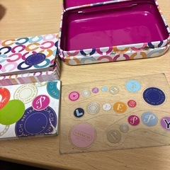 コーチの入れ物とメモ帳とシールの画像