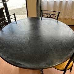 木製丸テーブルと椅子3脚の画像