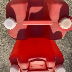 灯油缶二つと給油ホースの画像