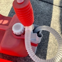 灯油缶二つと給油ホースの画像