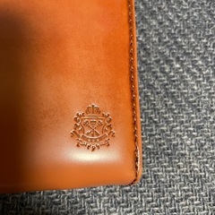 レザー ブラウン 長財布 エンブレム付きの画像