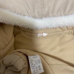 フード付きベージュダウンコートの画像