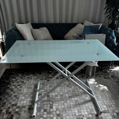 高さ調整可能な透明ガラステーブル。の画像