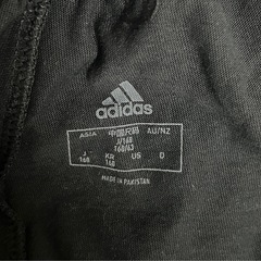 adidasの3本ラインデザインの黒いハーフパンツ 160の画像