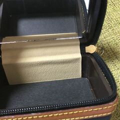 黒地に金色の靴の柄が特徴的な小物入れ。の画像