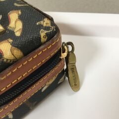 黒地に金色の靴の柄が特徴的な小物入れ。の画像