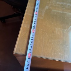 ガラステーブルマット付きの木製机の画像