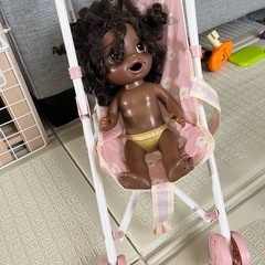 カールした黒髪のドールとベビーカーの画像