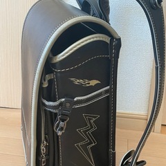 フラッシュデザインの黒いランドセル、ジッパーポケット付きで機能的。の画像