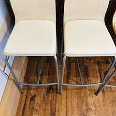 シンプルでモダンなデザインのベージュのダイニングチェア、木製座面と金属脚部。 の画像