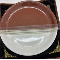 陶器製茶色と白の円形皿の画像