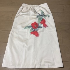 浅い緑シャツと花柄白いスカートの画像